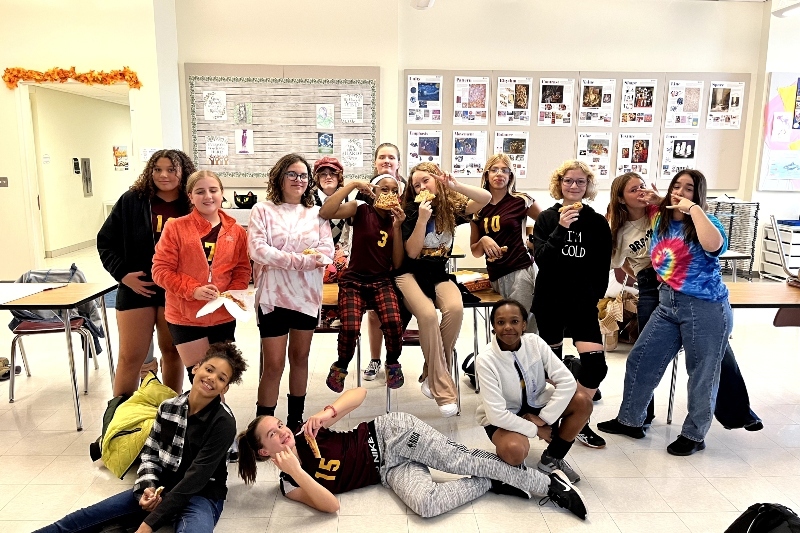 A large group of Jackson Preparatory & Early College students smile and pose for the camera in one of their classrooms.
