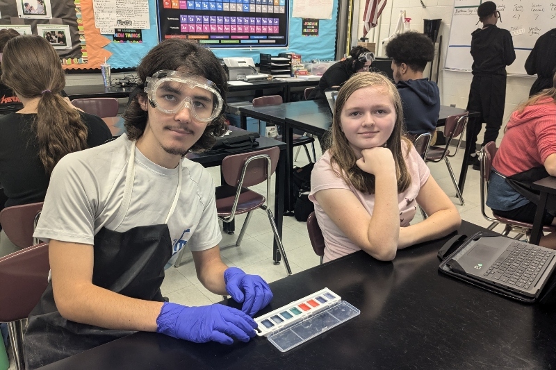 Two Jackson Preparatory & Early College high school students, a boy and a girl, sit at a table in a classroom.