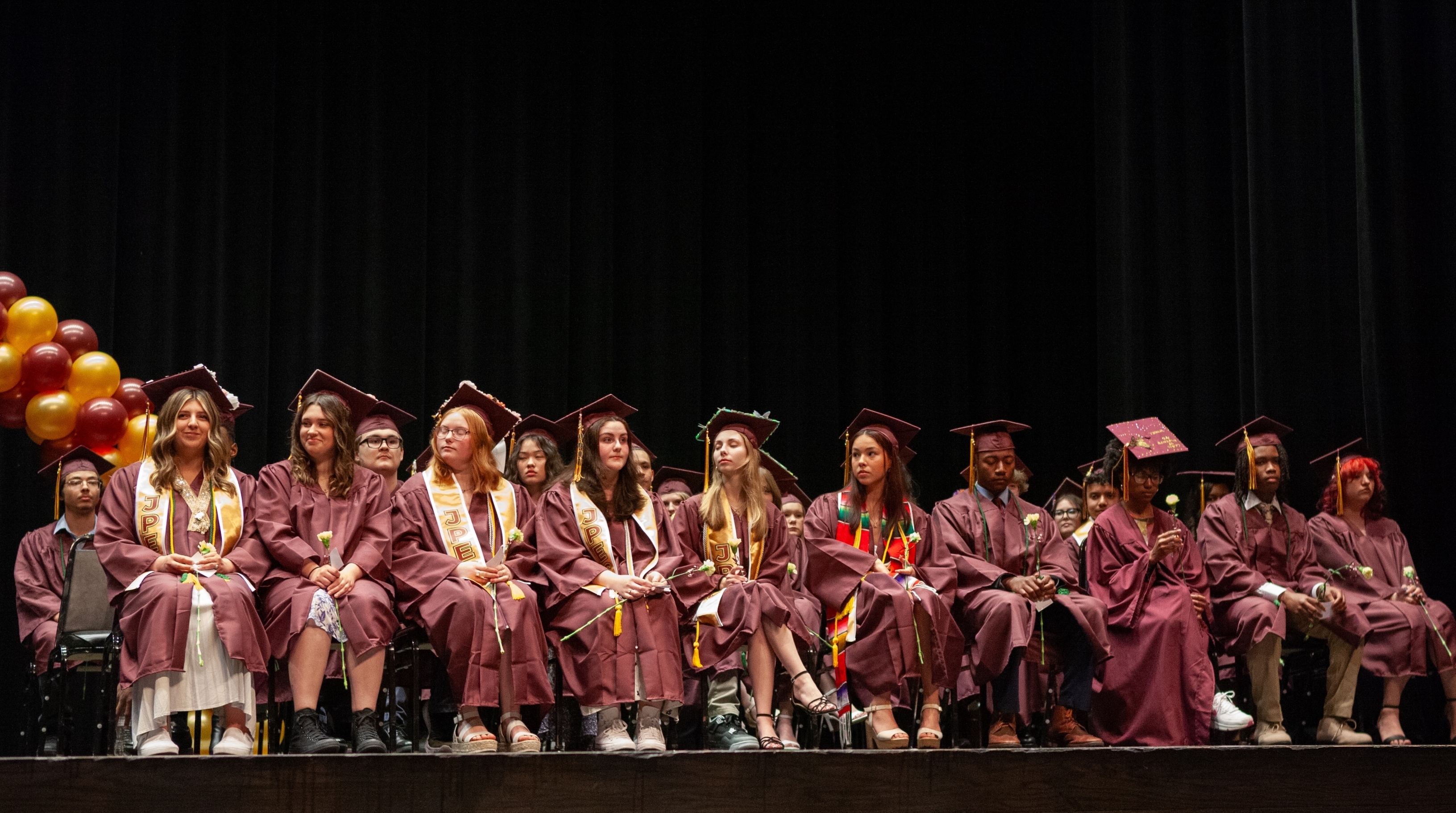 graduates on stage in caps and gowns