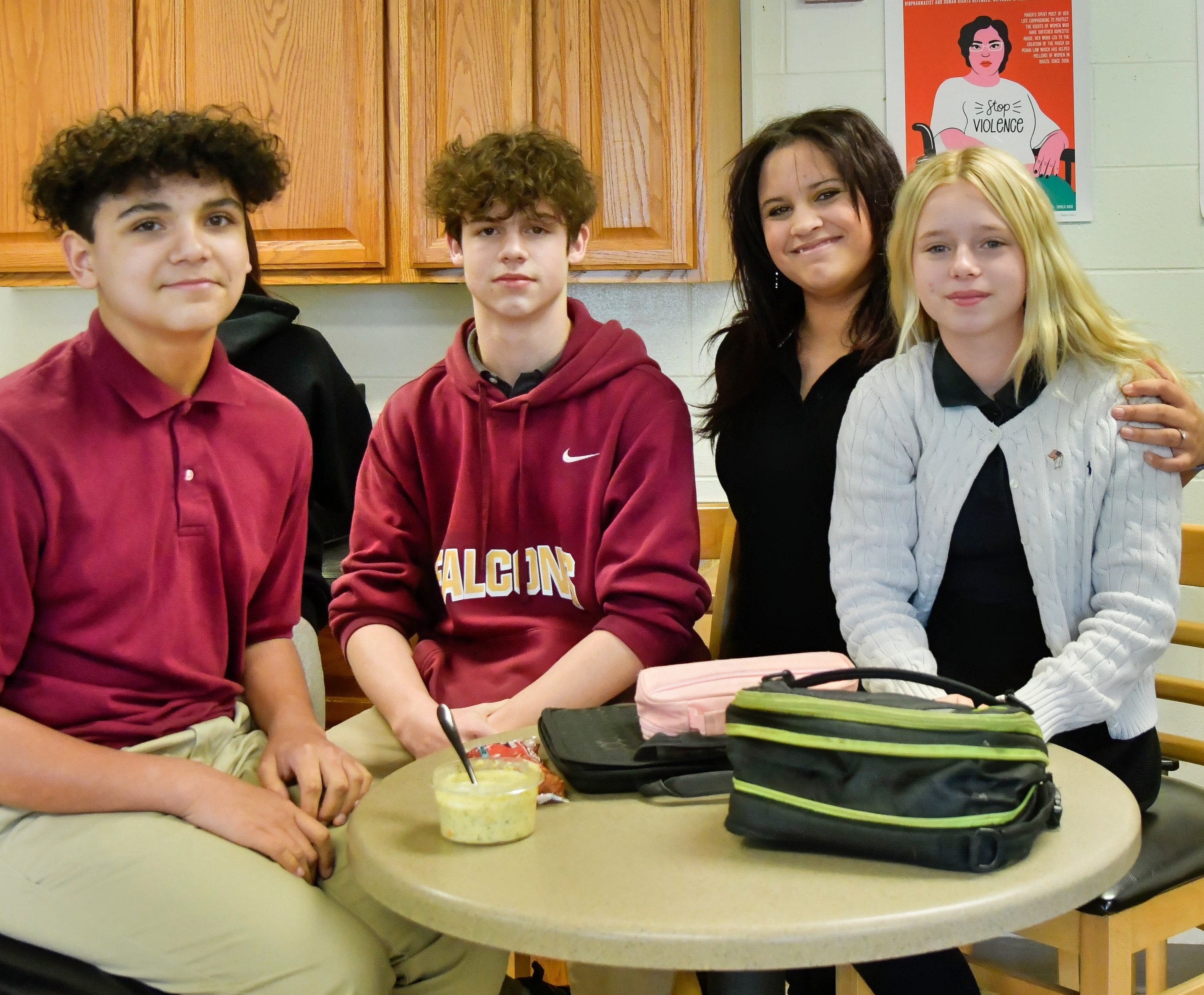 4 Jackson Preparatory & Early College students sit around a lunch table smiling.