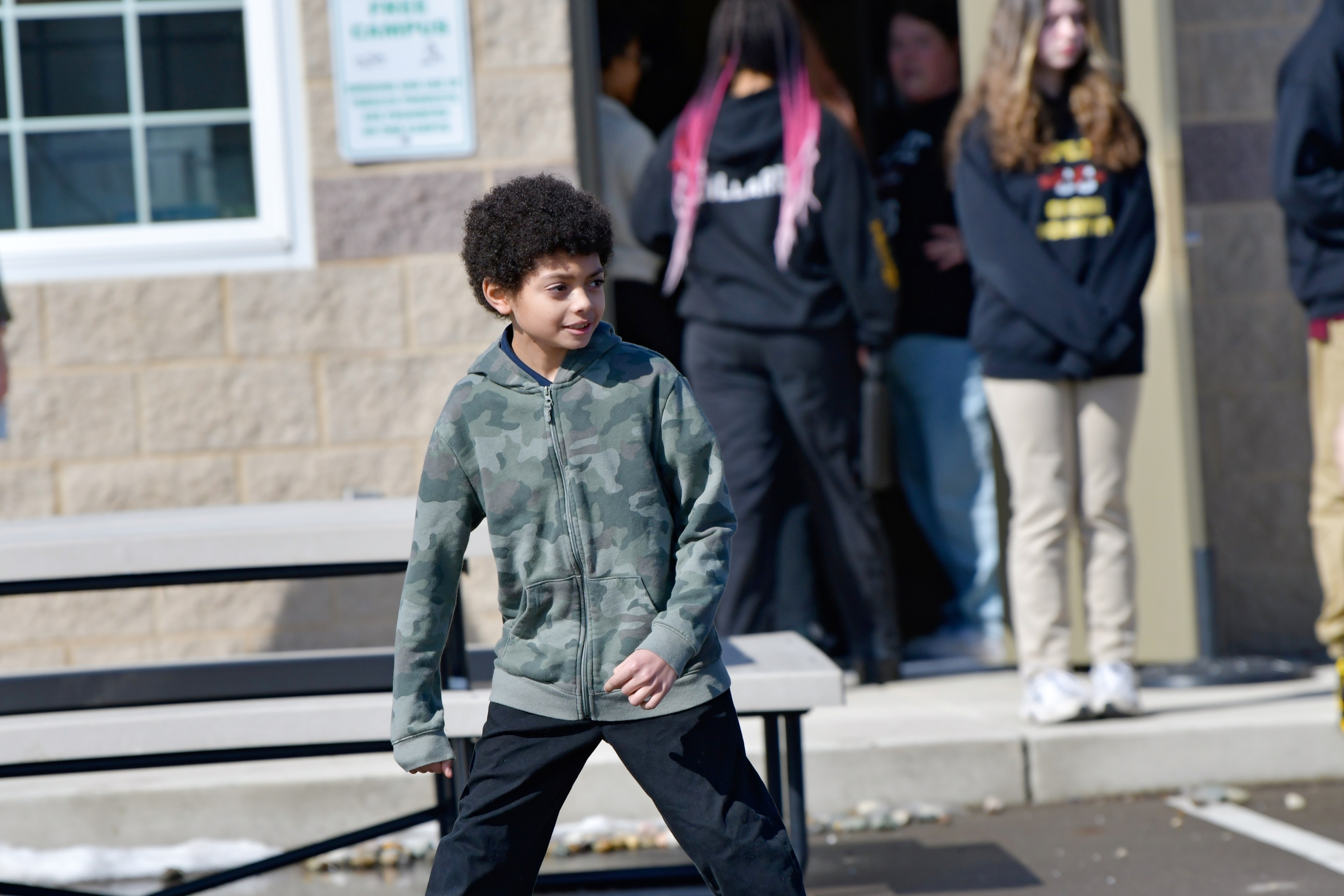 A Jackson Preparatory & Early College middle school student stands outside the school building.