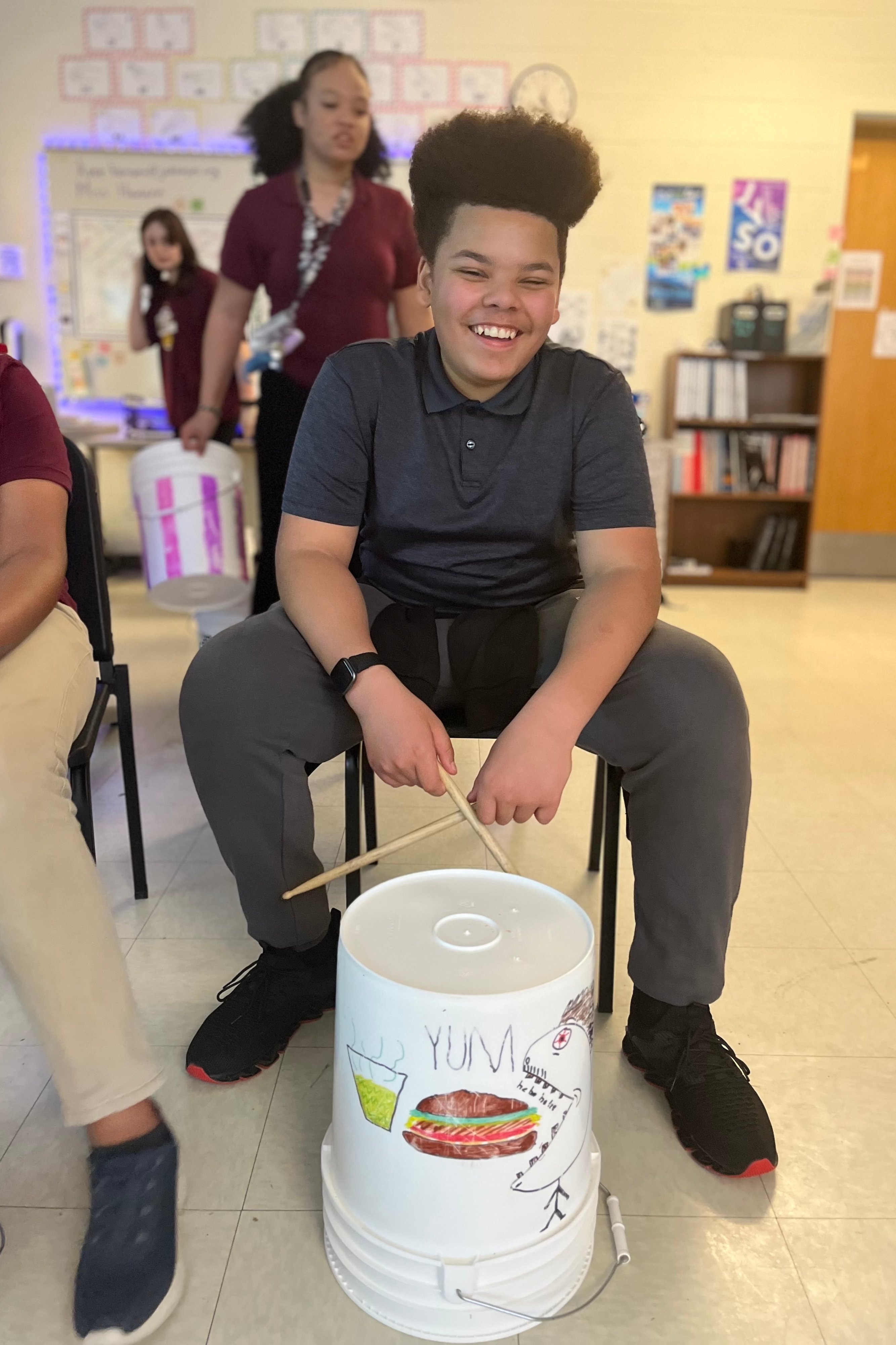 A Jackson Preparatory & Early College student smiles while bucket-drumming.