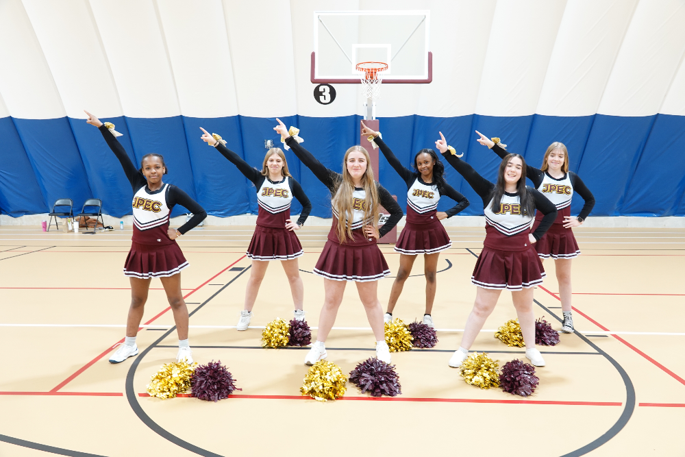 6 Jackson Preparatory & Early College cheerleaders perform a cheer during a school basketball game.